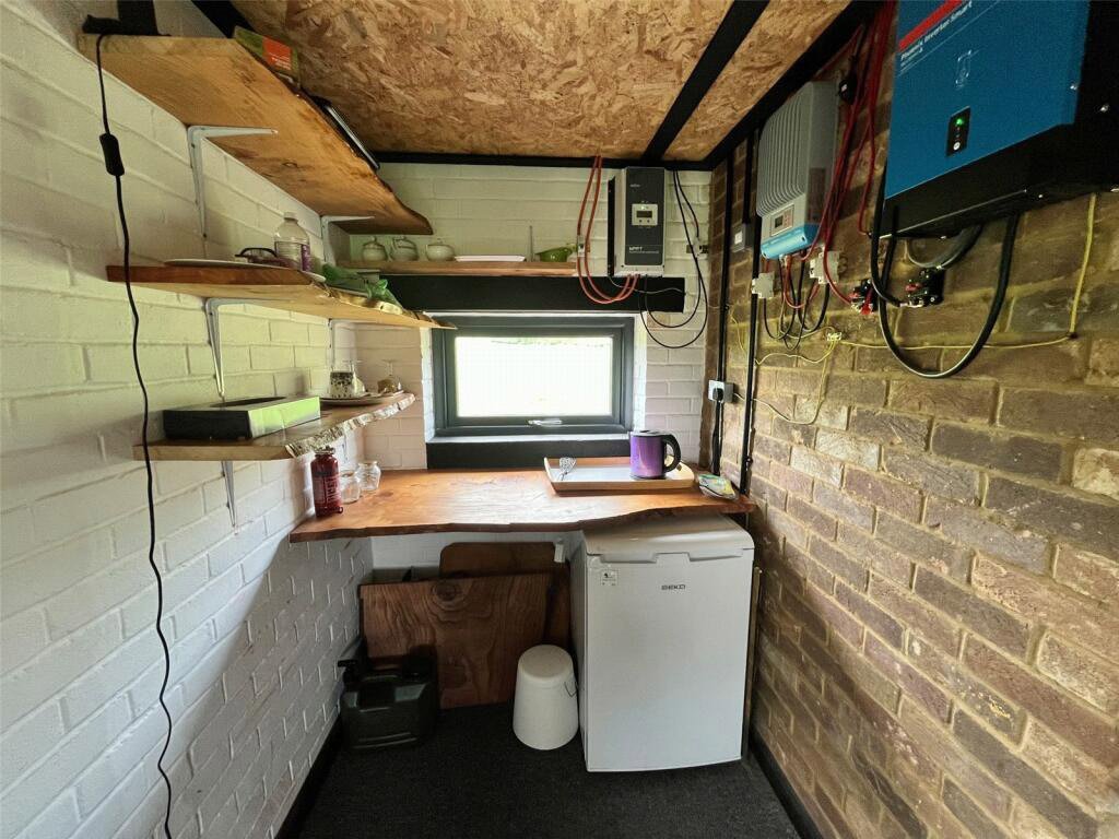 Tiny property in Welton, Northamptonshire, converted from an old pump station, is on sale for £75,000. Features solar panels, rainwater tank, and parking for four cars.