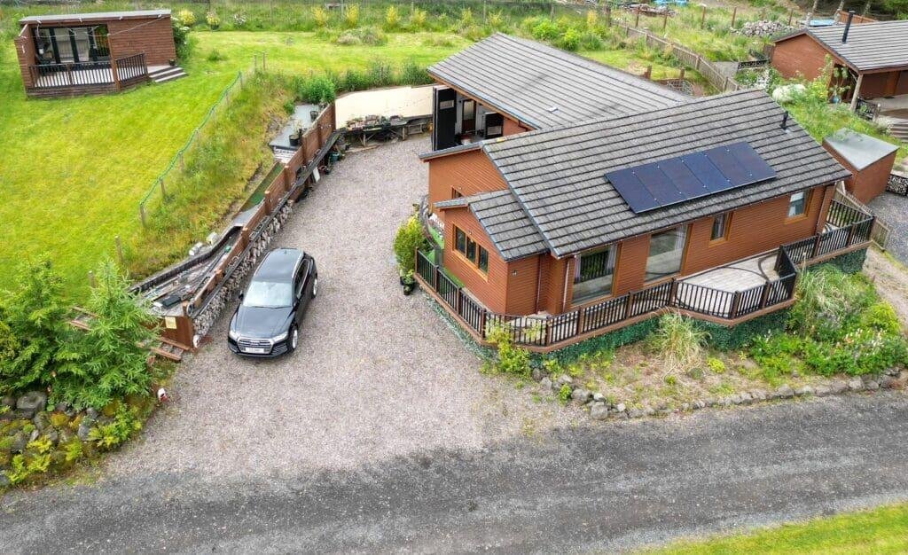 A quirky £300,000 bungalow near Kinross, Scotland, features a full model railway around the driveway, spacious living areas, two bedrooms, and a huge garage with conversion potential.