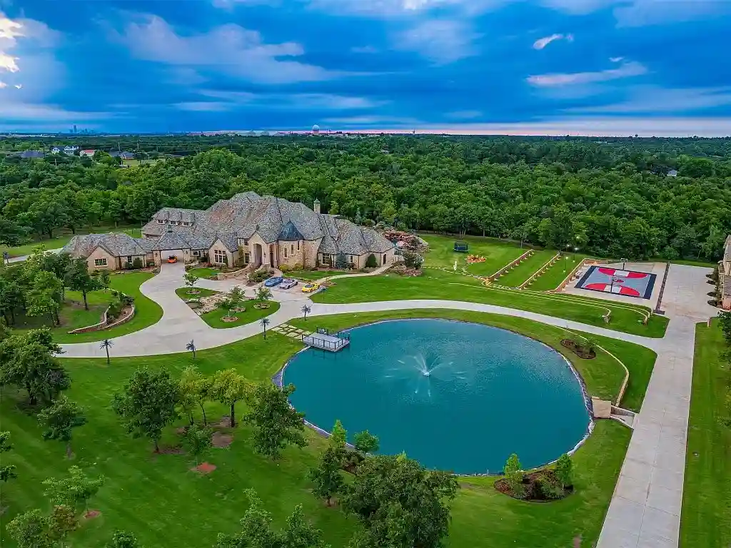 Luxury $17M mansion in Oklahoma City boasts 8 bedrooms, 16 bathrooms, dance floor, bar, bowling alley, sports courts, 70,000-gallon pool, and 36 acres of land. Ultimate entertainer's paradise.