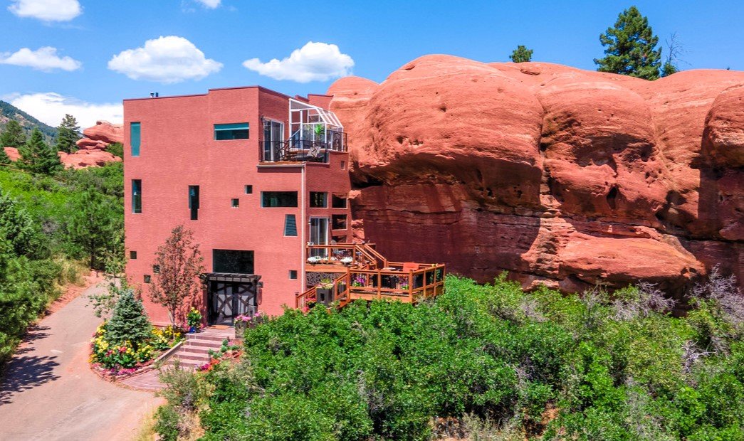 Explore the unique 'Rock House' in Larkspur, Colorado—built into a 200-million-year-old rock face, this 4-level home offers stunning natural views for just under $1M.