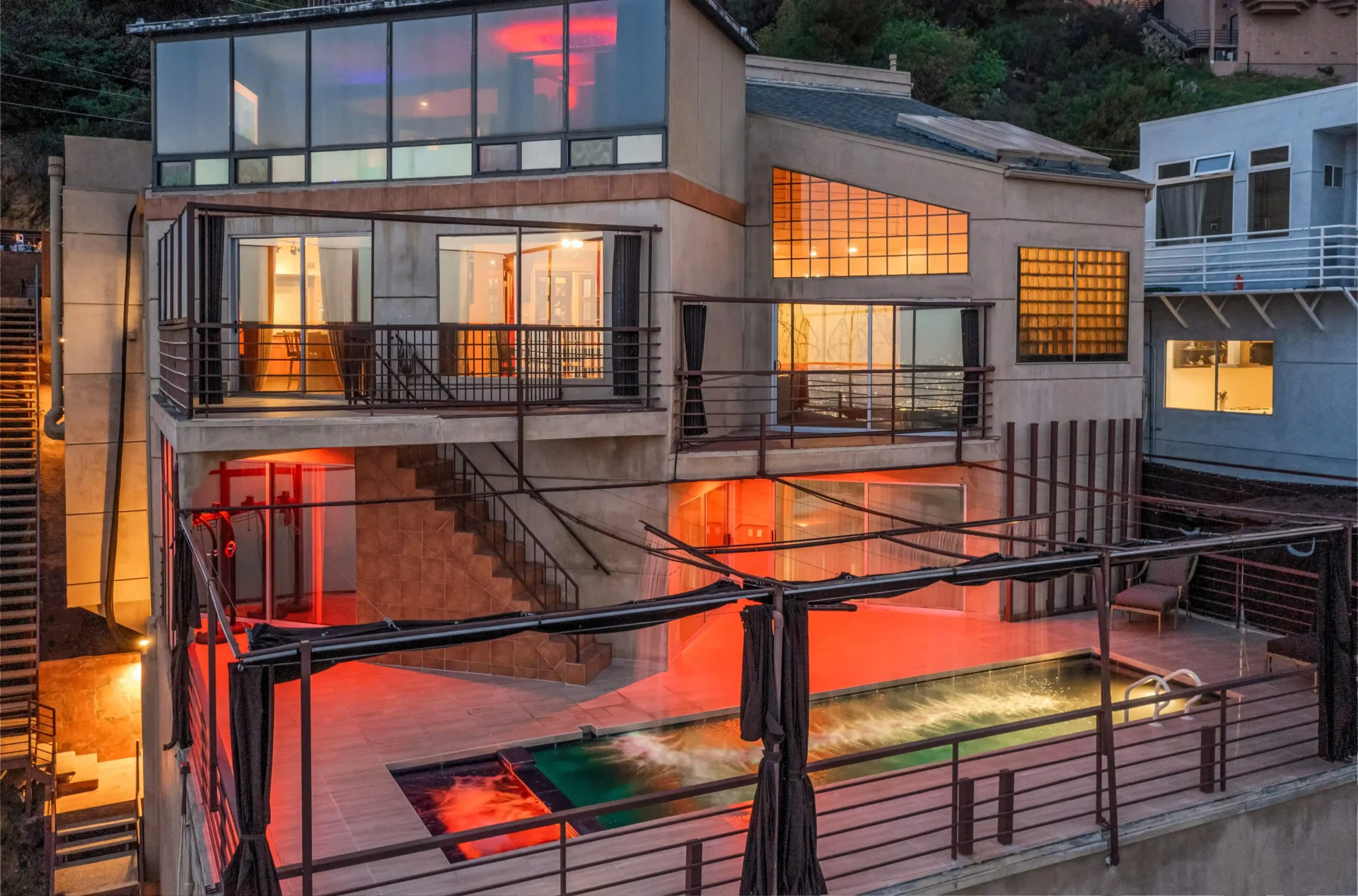 A "mini Playboy mansion" in LA, owned by photographer Richard Franklin, is on the market for $10M. Features include a nightclub, stripper pole, rooftop cabana, and stunning city views.