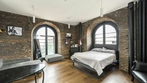 Historic London flat inside a converted church is available for rent at £4,000 per month, featuring five storeys, modern design, and stunning city views.