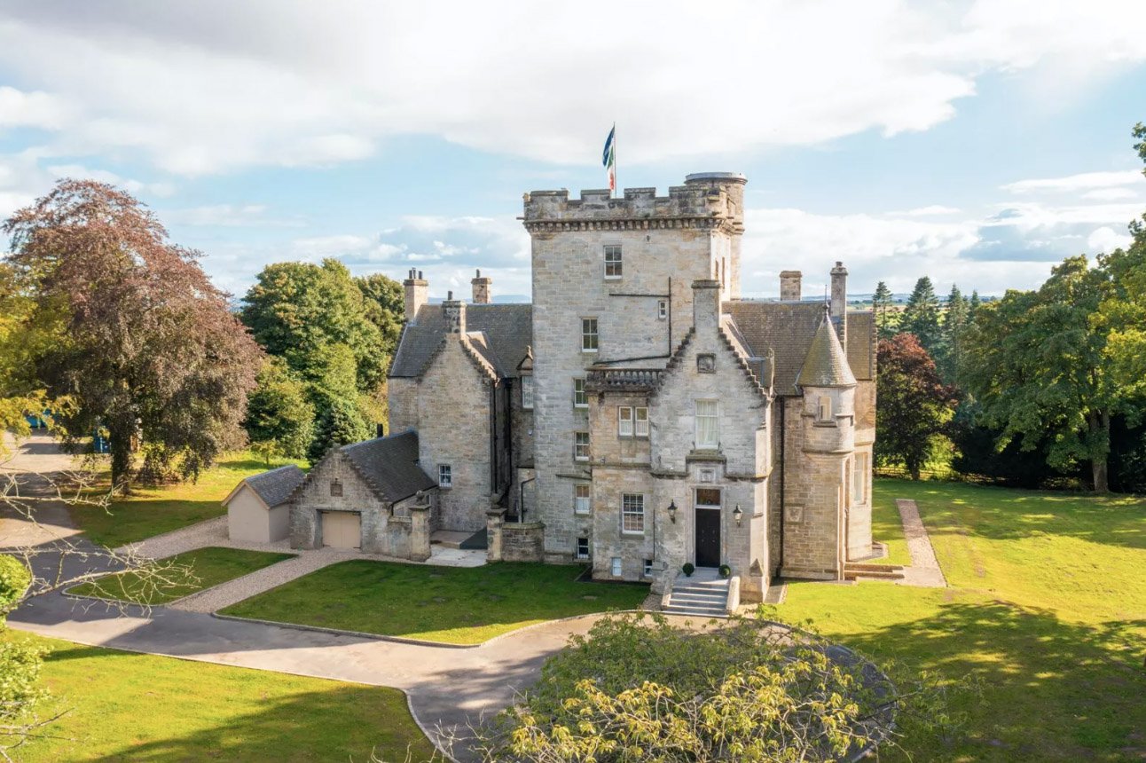 A breathtaking 1864 Scottish castle near Edinburgh, featuring eight bedrooms, modern interiors, a library, and a Biomass heating system, is on sale for £3.95M via Strutt & Parker.