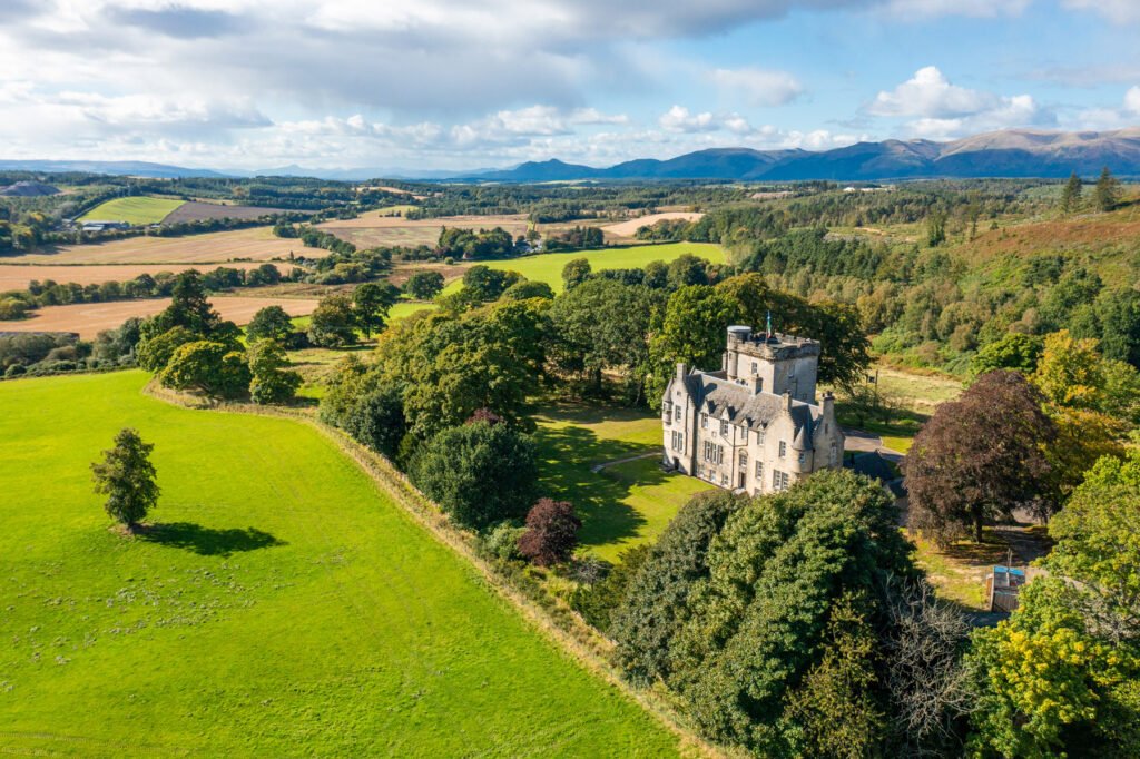 A breathtaking 1864 Scottish castle near Edinburgh, featuring eight bedrooms, modern interiors, a library, and a Biomass heating system, is on sale for £3.95M via Strutt & Parker.