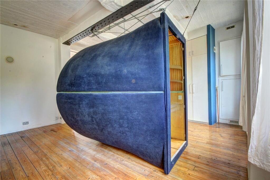 Bizarre Newcastle studio with a pod-style bed hanging from the ceiling still unsold after a £20k price drop. Modern design, Tyne Bridge views, £210k.