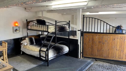 Stay in a cozy Lake District stable with a Friesian horse or Shetland pony as your roommate. This £350-per-night experience offers bunkbeds, grooming kits, and stunning views.