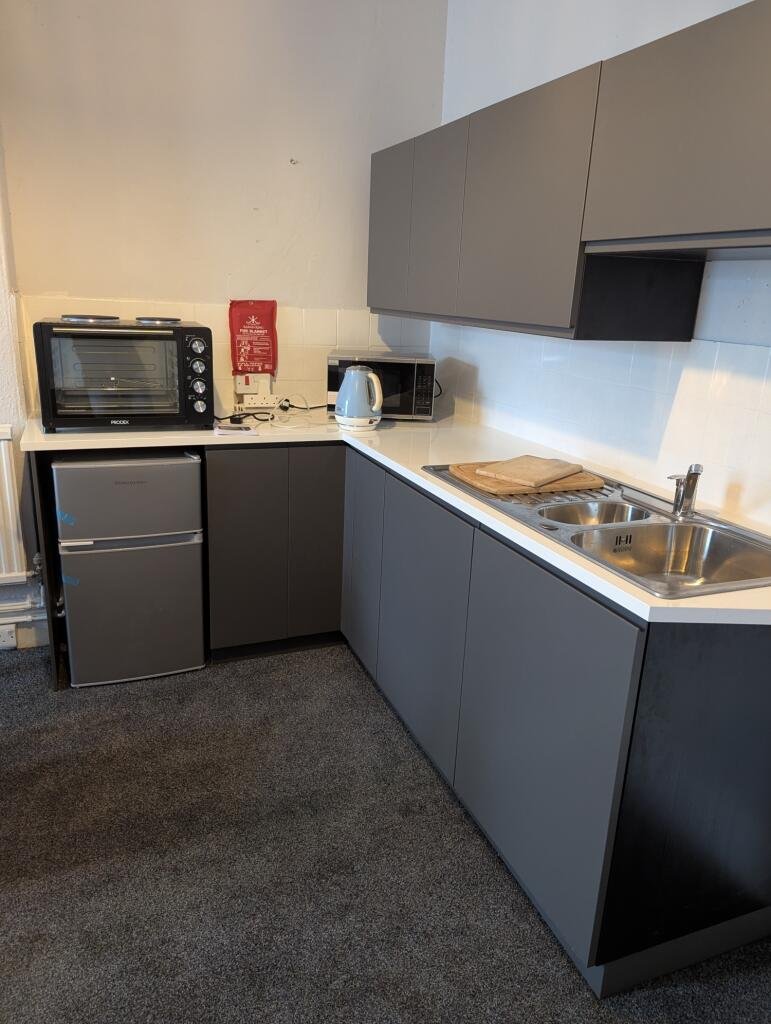 Bizarre property listing for a Dawlish bedsit features an “en-suite kitchen” but no private bathroom. Rent includes bills, but shared facilities spark online laughs.