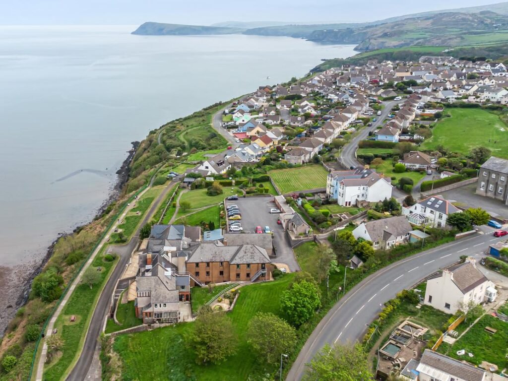 A stunning 27-bedroom former nunnery with sea views in Fishguard, South Wales, is on the market for £750,000. The property includes a chapel, cottages, and panoramic harbor views.