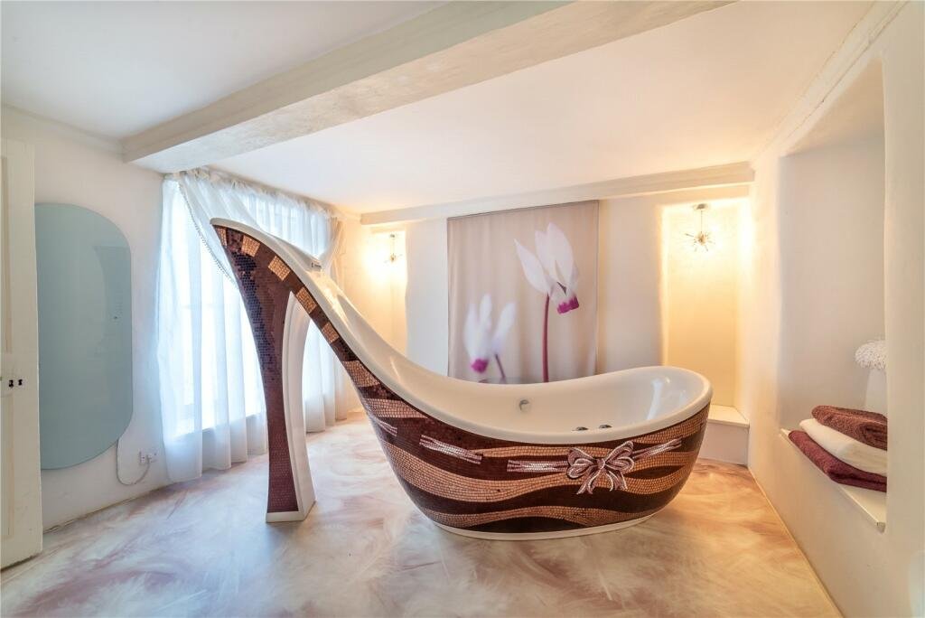 Grade II listed Conwy cottage, built in 1441, shocks buyers with a giant high heel bathtub. Quirky design meets medieval charm in this £875,000 one-of-a-kind home.