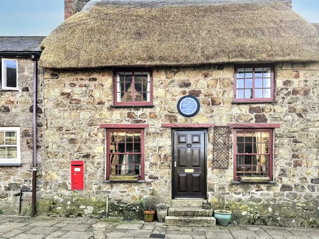 Bob Fitzsimmons’ childhood home, a charming Grade II listed cottage in Helston, Cornwall, is now for sale at £220,000, offering history, modern updates, and a serene garden.