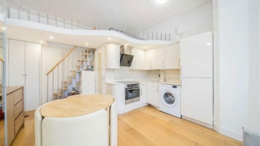 A tiny London flat with a mezzanine bed and safety spikes to prevent falls is on sale for £199,950. The compact space offers modern decor and good transport links.