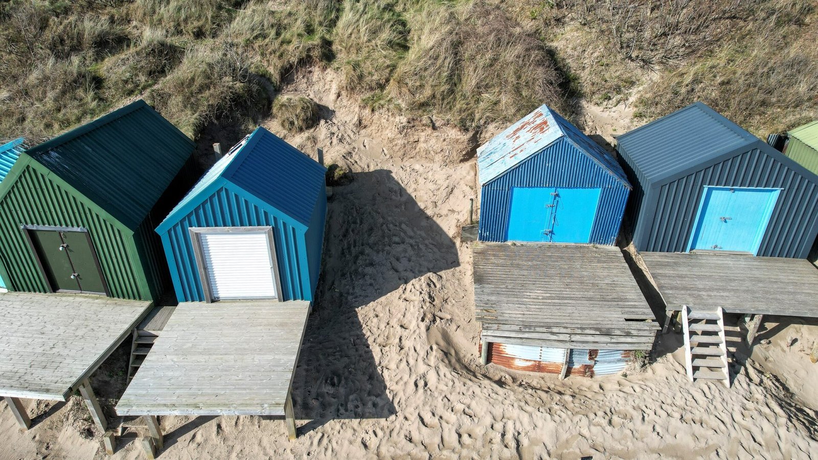 A tiny sand plot on Abersoch beach is up for sale at £100,000 - offering panoramic sea views and planning permission to build between beach huts near golden dunes.