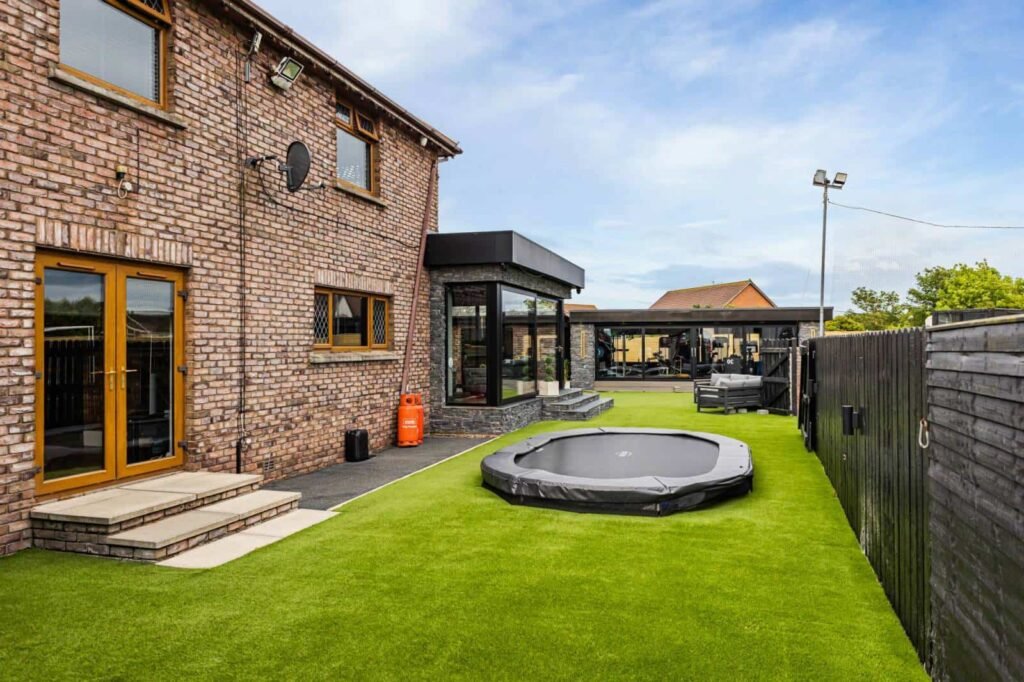 A five-bed Northern Ireland home with a full-size seven-a-side football pitch, gym, dog shower and luxe interiors is on sale for £435,000 offering fun and privacy.