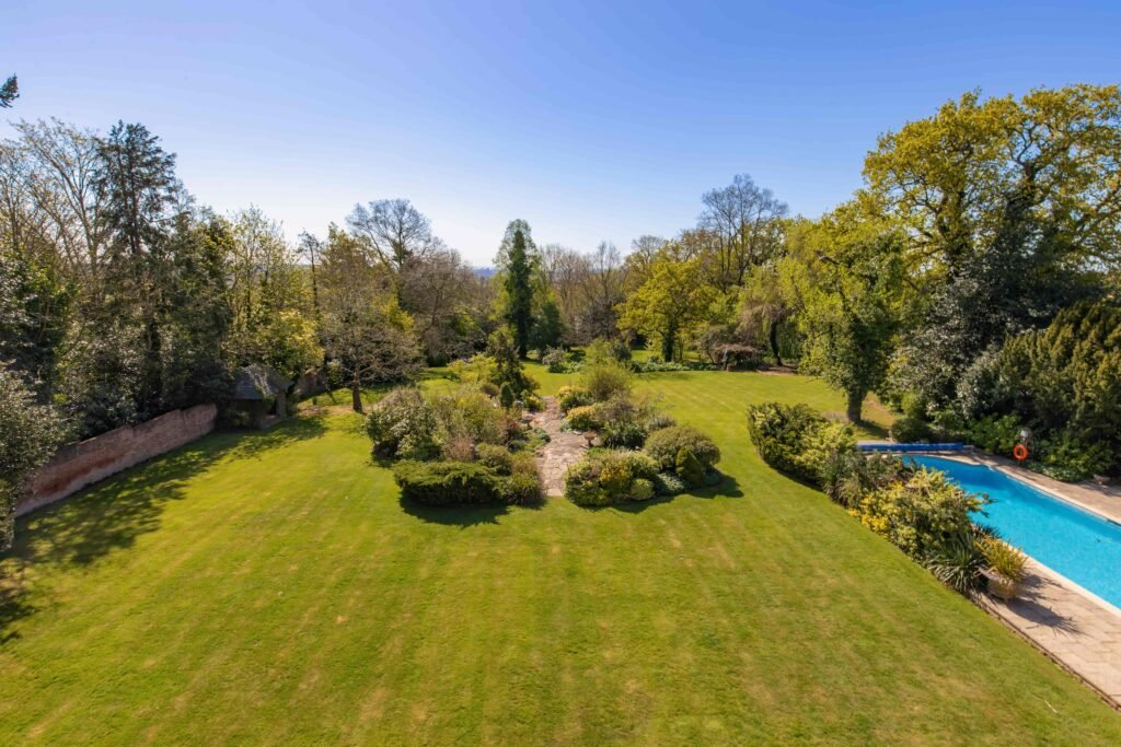 Stanley Kubrick’s former Elstree mansion with a pool, lush gardens, and film history is for sale at £6.95m, just in time for London’s sizzling summer heatwave.