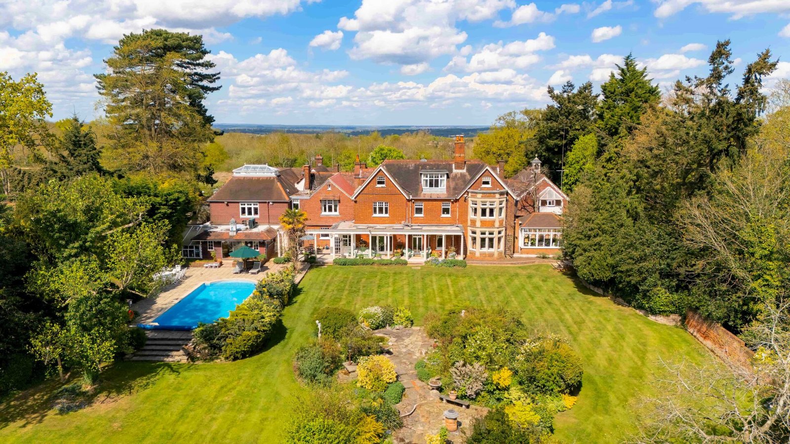 Stanley Kubrick’s former Elstree mansion with a pool, lush gardens, and film history is for sale at £6.95m, just in time for London’s sizzling summer heatwave.