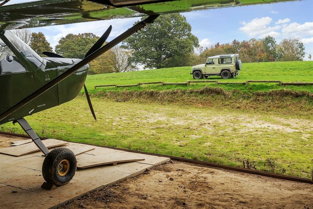 This £945k East Sussex barn home has 3 beds, a vineyard, 12.5 acres, stunning valley views and its own private airstrip and hangar for microlight aircraft.
