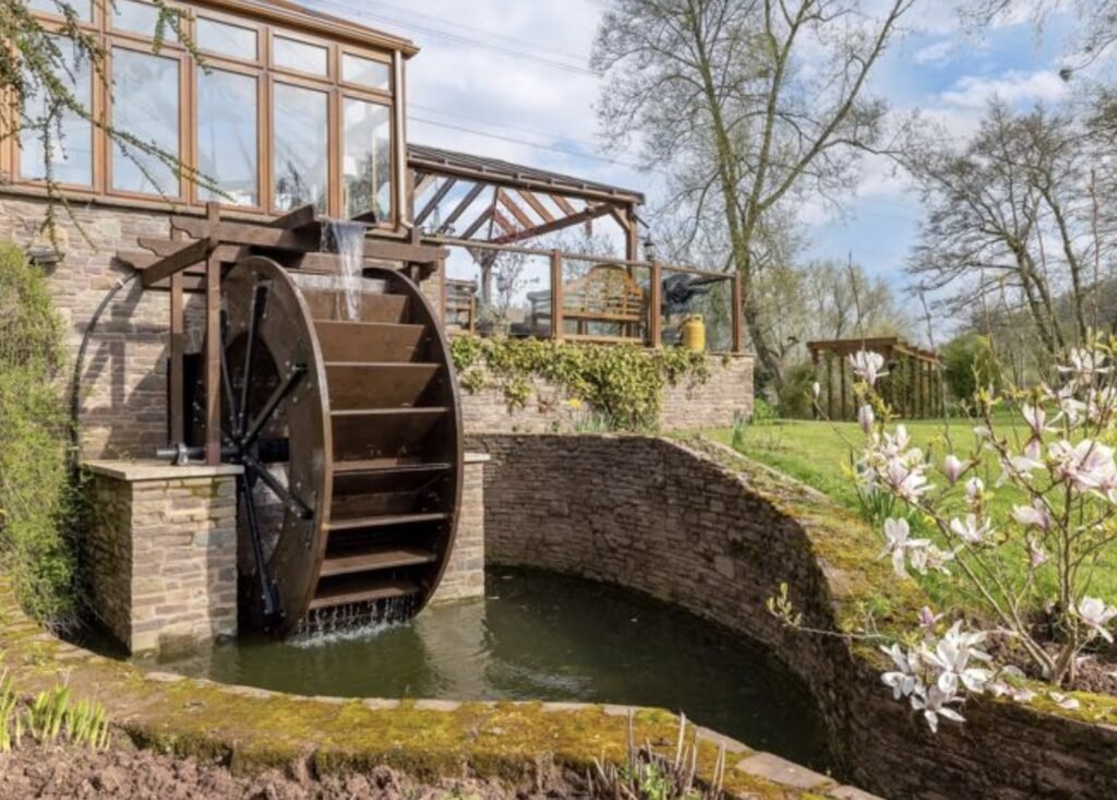 A £1.5m riverside home in Wales with a working water wheel, lush gardens, fishing rights and a two-bed annexe offers luxury countryside living on nearly 14 acres.