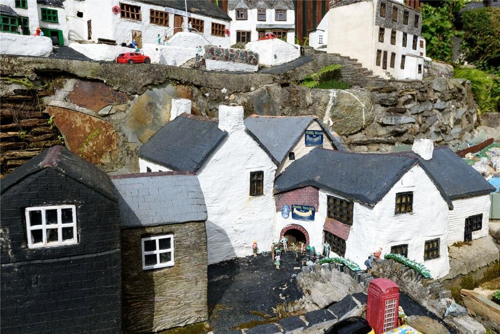 A detailed model village in scenic Polperro, Cornwall is for sale at £710k including a 3-bed home, mini harbour, railway and folklore exhibit attracting thousands yearly.