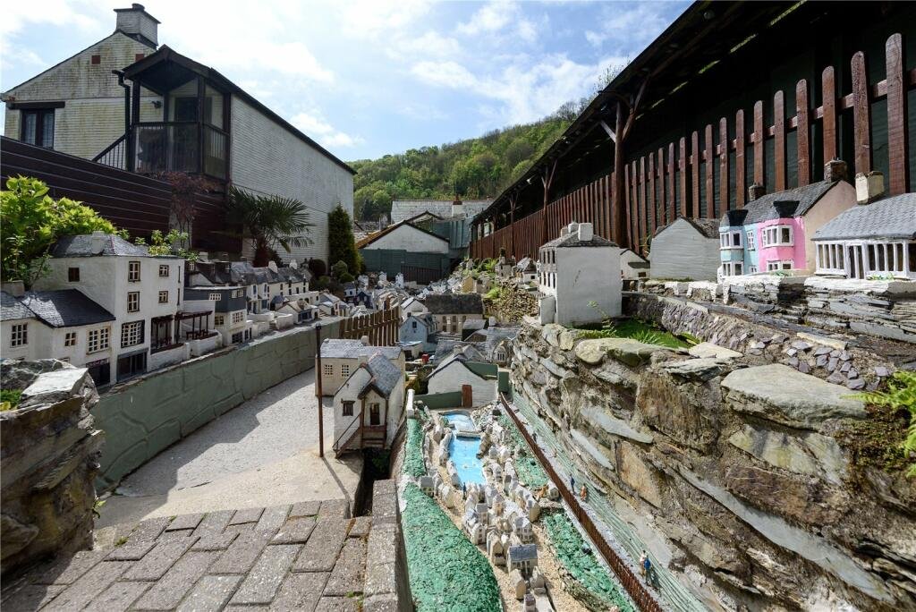 A detailed model village in scenic Polperro, Cornwall is for sale at £710k including a 3-bed home, mini harbour, railway and folklore exhibit attracting thousands yearly.