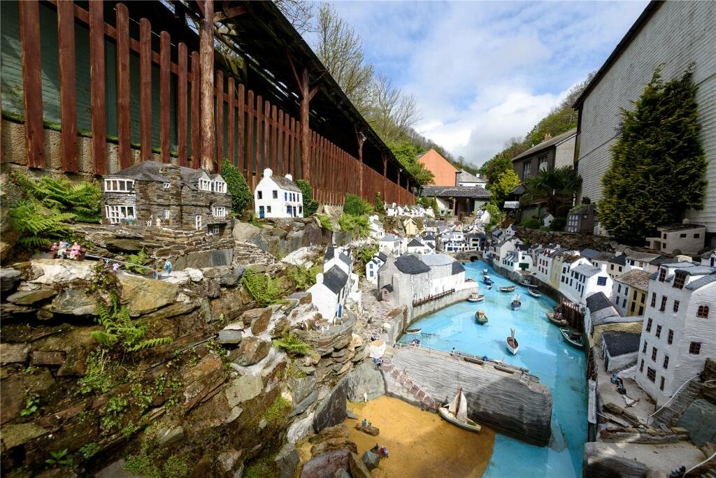 A detailed model village in scenic Polperro, Cornwall is for sale at £710k including a 3-bed home, mini harbour, railway and folklore exhibit attracting thousands yearly.