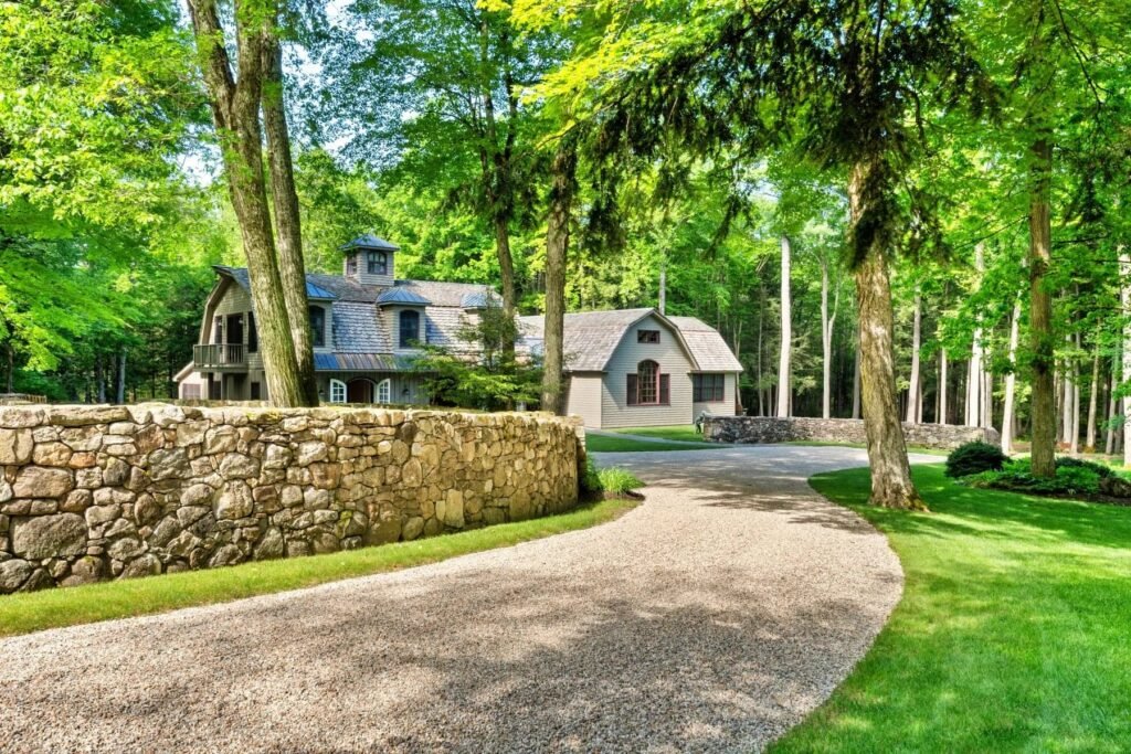 A \$3.25m Massachusetts estate features a quarry-carved pool with a 16ft waterfall, lush gardens, a canopy porch, and serene luxury across 3,459 sq ft of private grounds.