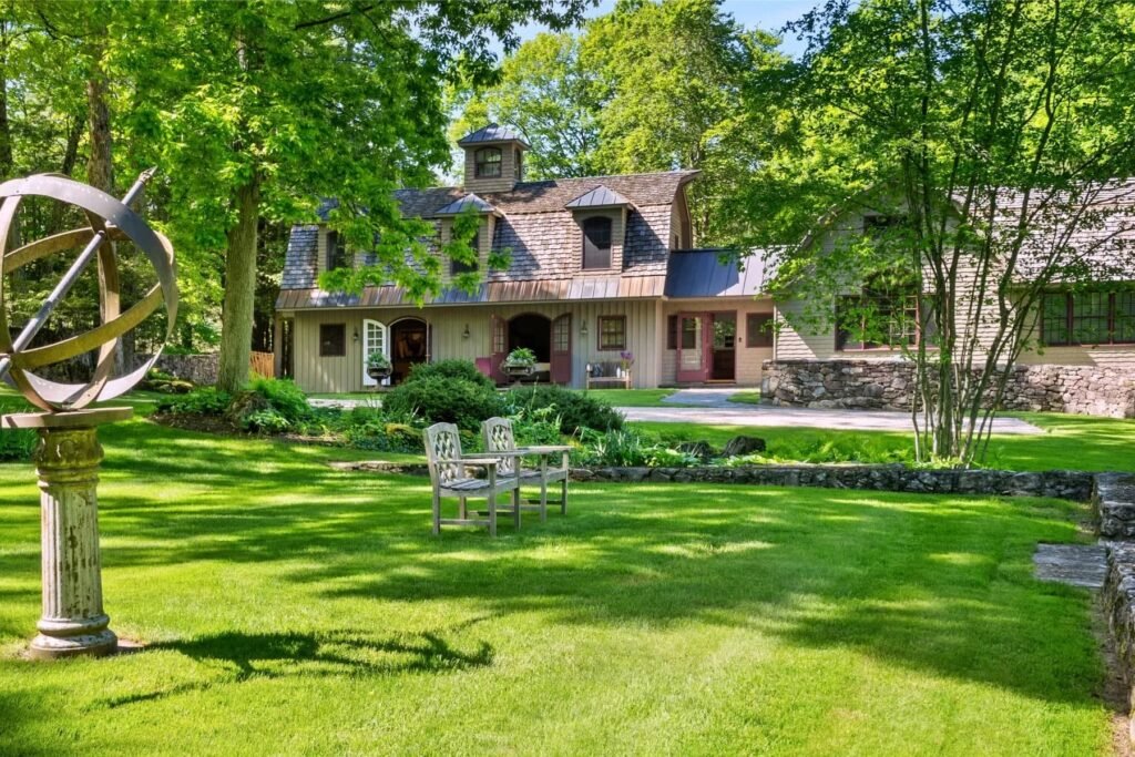 A \$3.25m Massachusetts estate features a quarry-carved pool with a 16ft waterfall, lush gardens, a canopy porch, and serene luxury across 3,459 sq ft of private grounds.