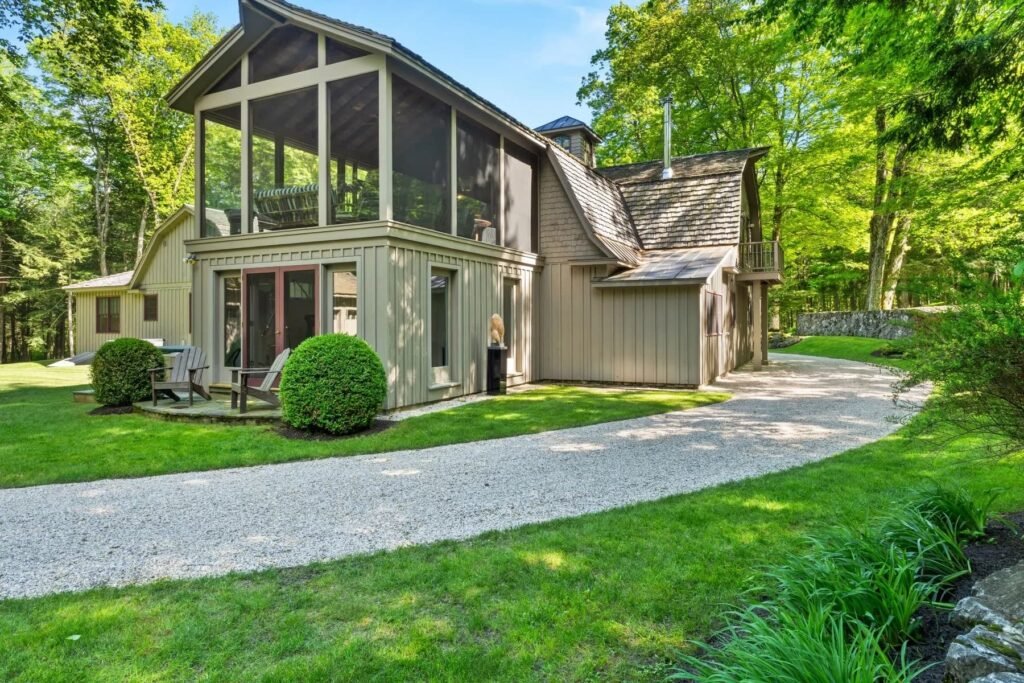 A \$3.25m Massachusetts estate features a quarry-carved pool with a 16ft waterfall, lush gardens, a canopy porch, and serene luxury across 3,459 sq ft of private grounds.