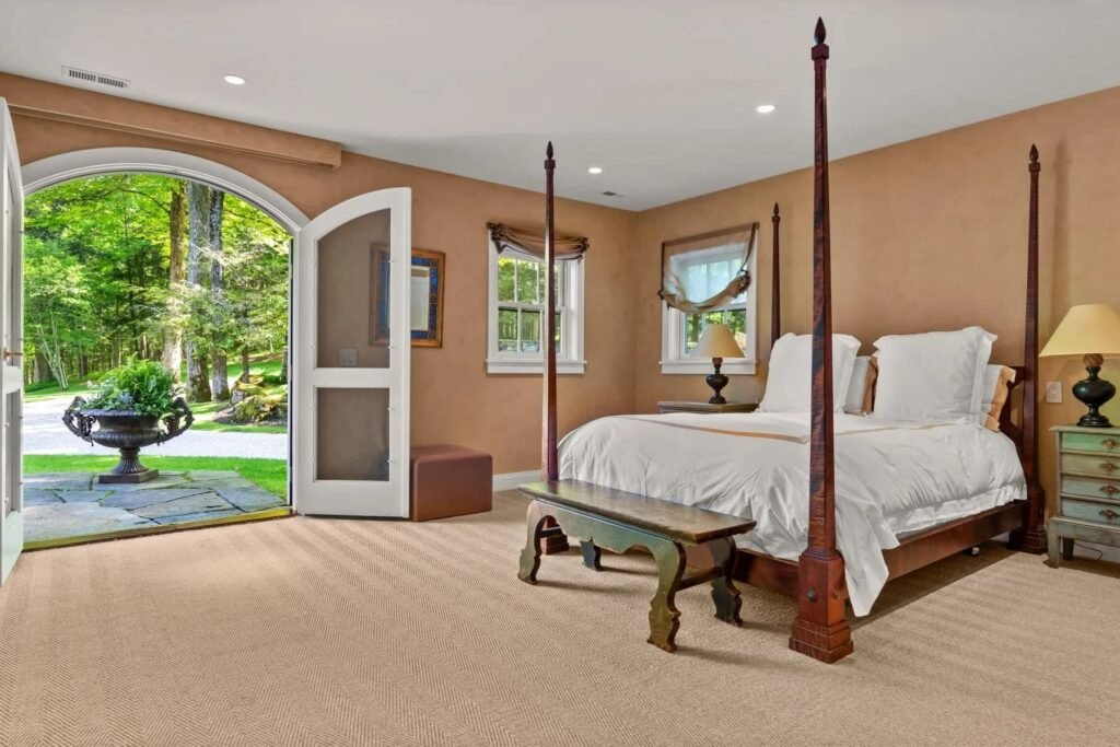A \$3.25m Massachusetts estate features a quarry-carved pool with a 16ft waterfall, lush gardens, a canopy porch, and serene luxury across 3,459 sq ft of private grounds.