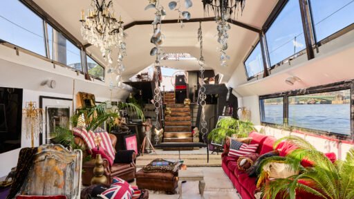 A £1.15m floating sculpture moored in Fulham, Wonderland is a mirrored grain barge turned bohemian home with chandeliers, Thames views and historic artistic charm.