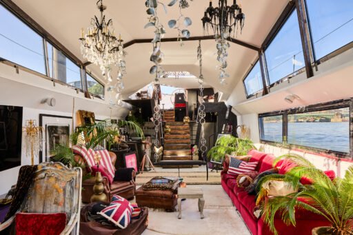 A £1.15m floating sculpture moored in Fulham, Wonderland is a mirrored grain barge turned bohemian home with chandeliers, Thames views and historic artistic charm.