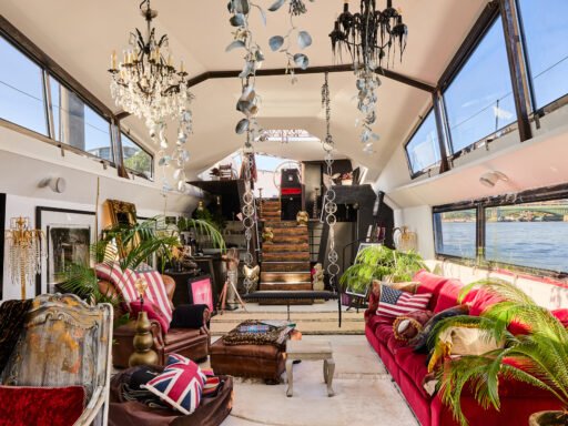 A £1.15m floating sculpture moored in Fulham, Wonderland is a mirrored grain barge turned bohemian home with chandeliers, Thames views and historic artistic charm.