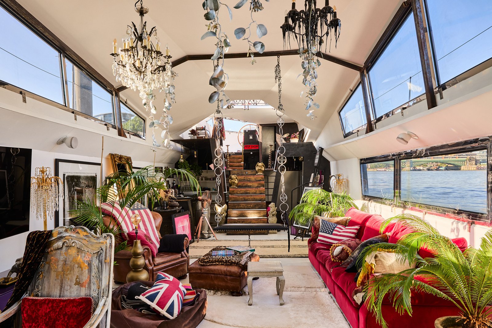 A £1.15m floating sculpture moored in Fulham, Wonderland is a mirrored grain barge turned bohemian home with chandeliers, Thames views and historic artistic charm.
