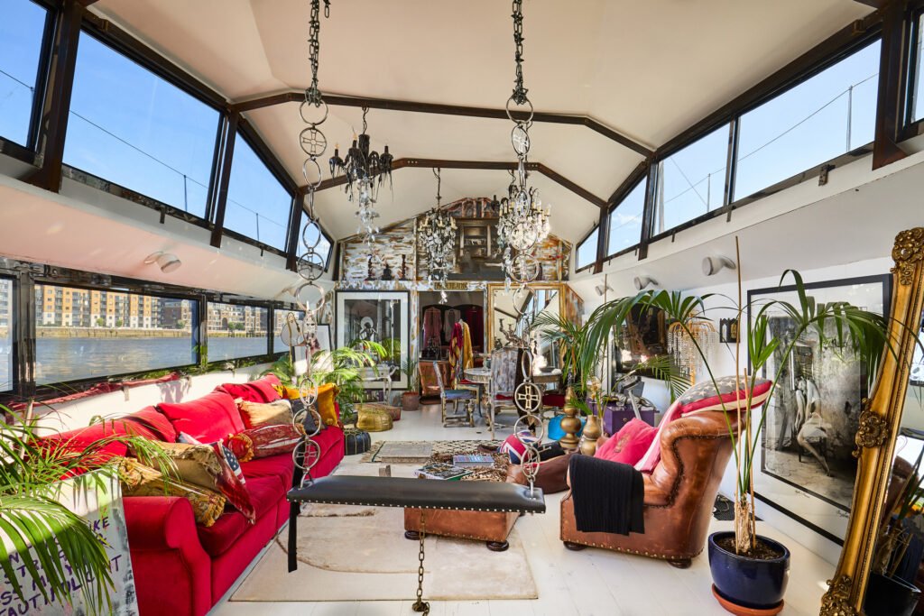 A £1.15m floating sculpture moored in Fulham, Wonderland is a mirrored grain barge turned bohemian home with chandeliers, Thames views and historic artistic charm.