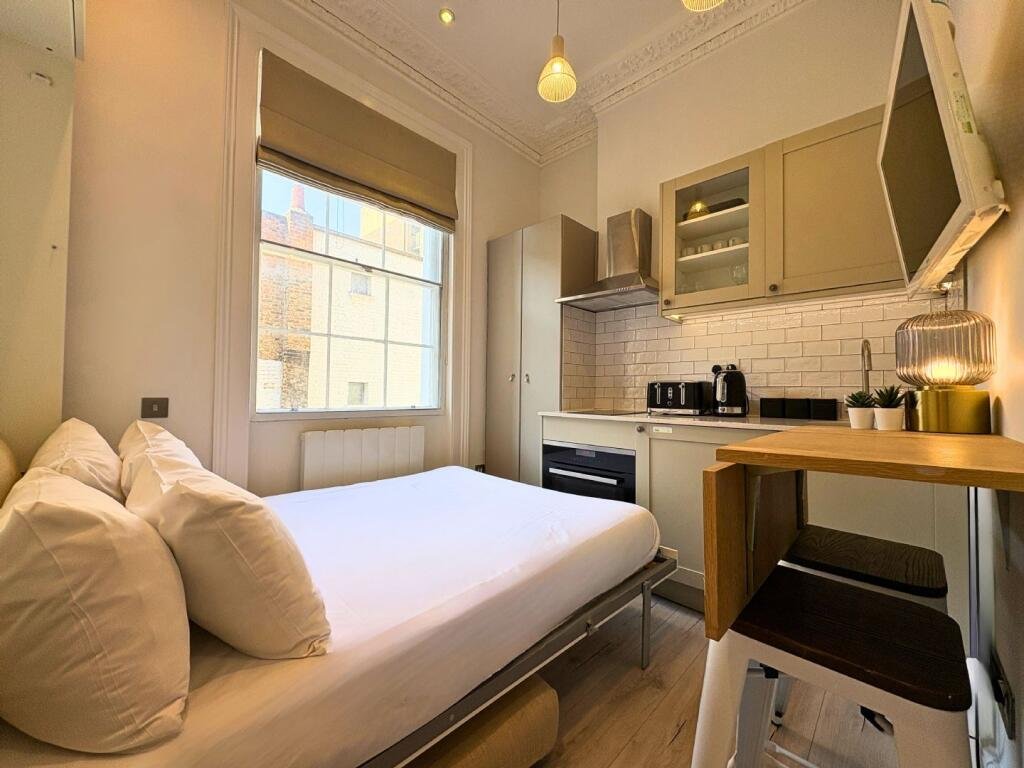Ingenious fold-away bed and modern shower maximize space in this £1,400 Baker Street studio flat, where you can cook from bed and enjoy bills included for £63 weekly.