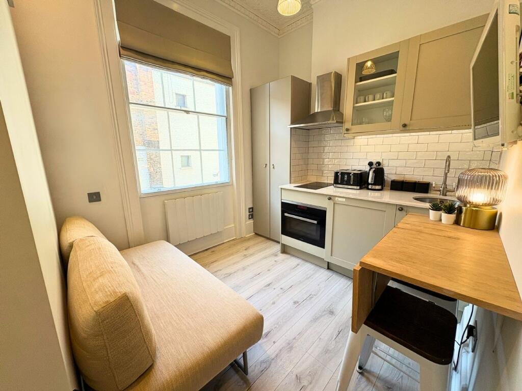 Ingenious fold-away bed and modern shower maximize space in this £1,400 Baker Street studio flat, where you can cook from bed and enjoy bills included for £63 weekly.