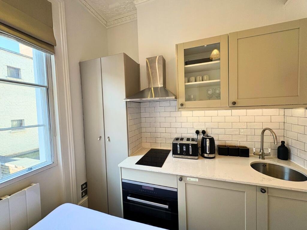 Ingenious fold-away bed and modern shower maximize space in this £1,400 Baker Street studio flat, where you can cook from bed and enjoy bills included for £63 weekly.