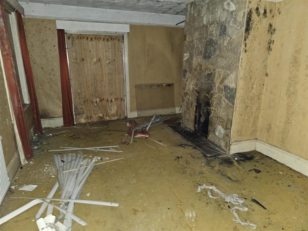 A £450,000 Winchester home with boarded windows, blackened walls and renovation needs is up for auction, with buyers advised to bring a torch and wear sturdy shoes.