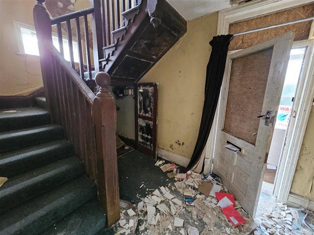 A £450,000 Winchester home with boarded windows, blackened walls and renovation needs is up for auction, with buyers advised to bring a torch and wear sturdy shoes.
