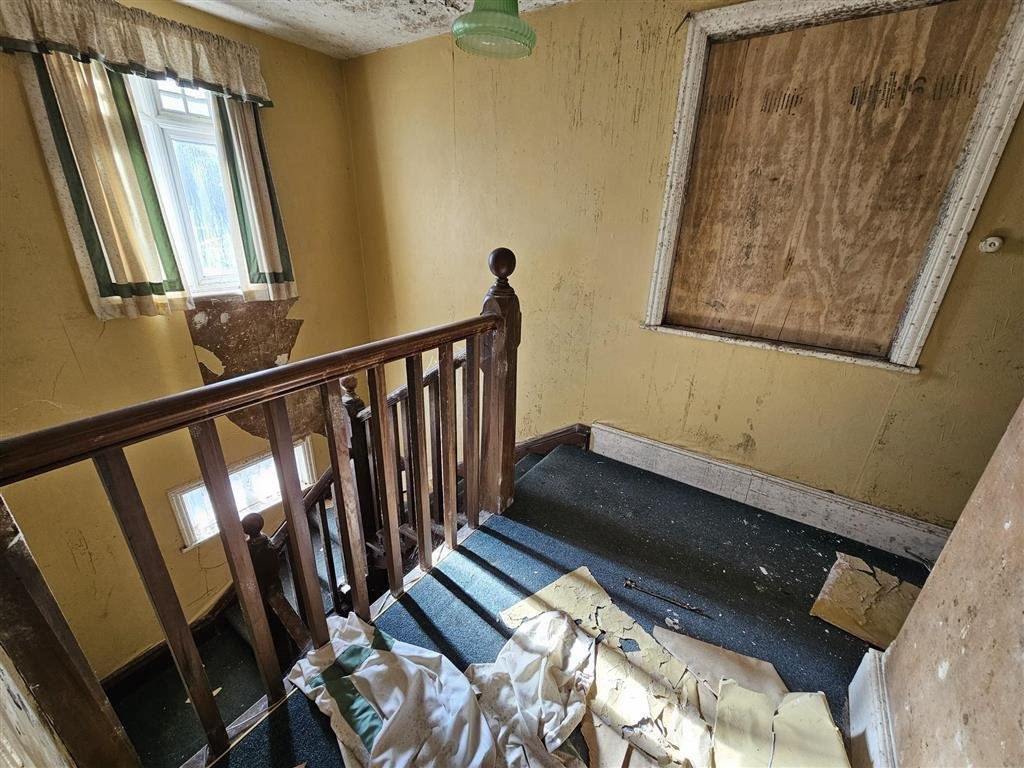 A £450,000 Winchester home with boarded windows, blackened walls and renovation needs is up for auction, with buyers advised to bring a torch and wear sturdy shoes.