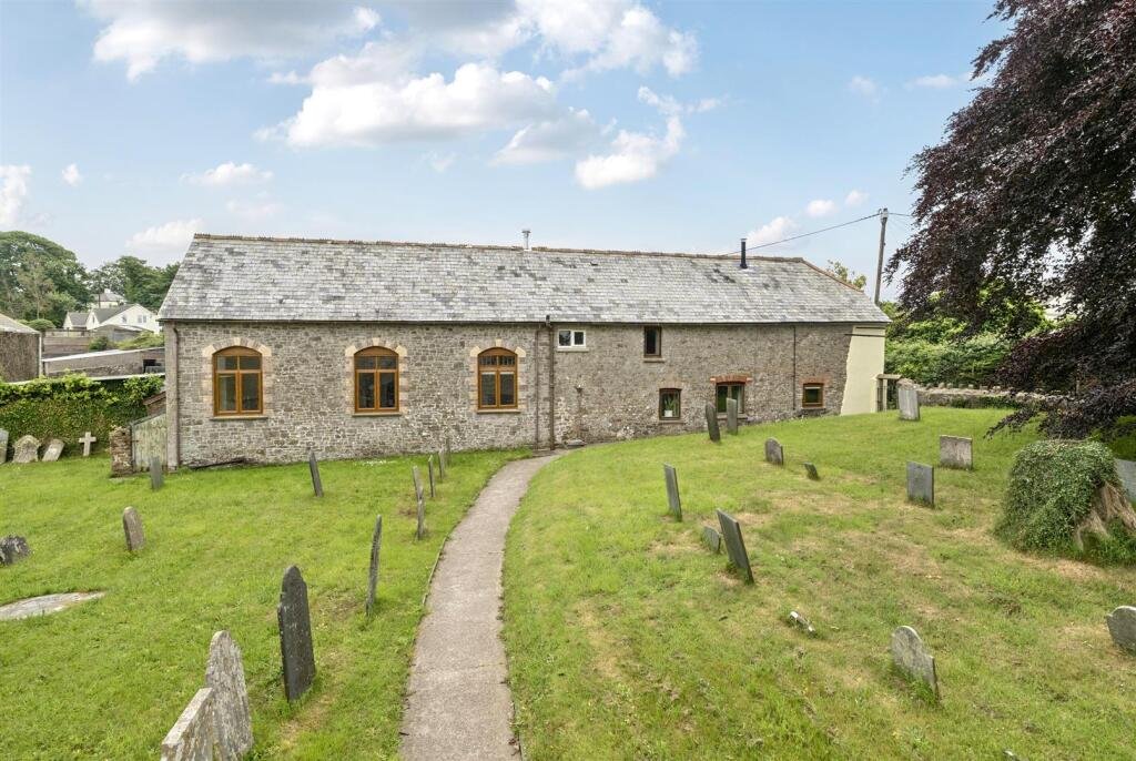 A restored 1876 schoolhouse in Devon with church views and a graveyard garden hits the market for £525,000, offering charm, history, and countryside tranquility.