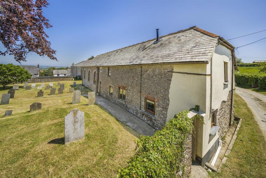 A restored 1876 schoolhouse in Devon with church views and a graveyard garden hits the market for £525,000, offering charm, history, and countryside tranquility.