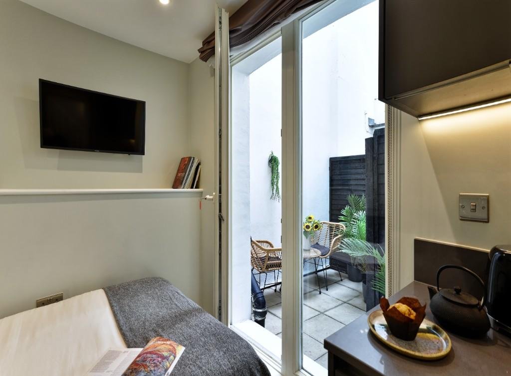 Tiny Marylebone flat with sofa bed, shared kitchen, and compact courtyard costs £2,578 a month, offering luxury service but less space than a house in Shildon.