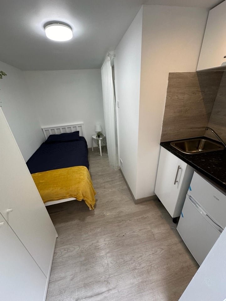 A £750-a-month Canning Town studio with no windows and a curtain for a bathroom door offers minimal space, limited kitchen facilities, and all bills included in rent.
