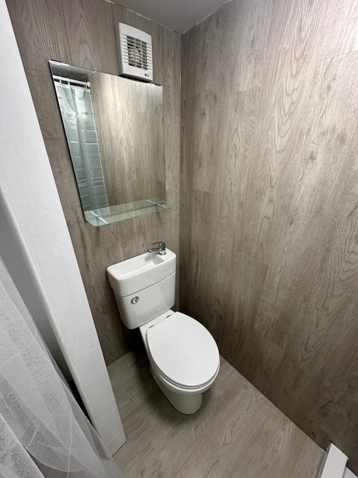 A £750-a-month Canning Town studio with no windows and a curtain for a bathroom door offers minimal space, limited kitchen facilities, and all bills included in rent.