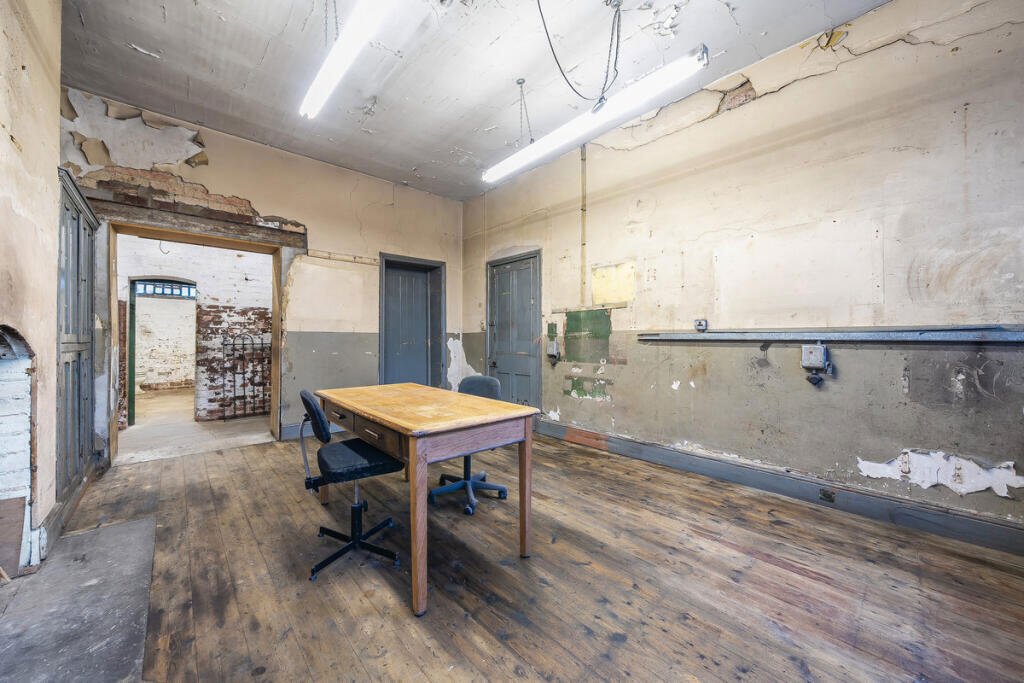 A historic 1887 police station in Marple with its own cell is for sale at £165,000, offering planning approval to convert it into a unique two-bedroom character home.