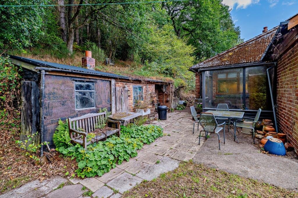 Secluded £520k woodland home in Shrewsbury with two bedrooms nearly one acre of gardens rare plants historic mine features and stunning views offers ultimate privacy.