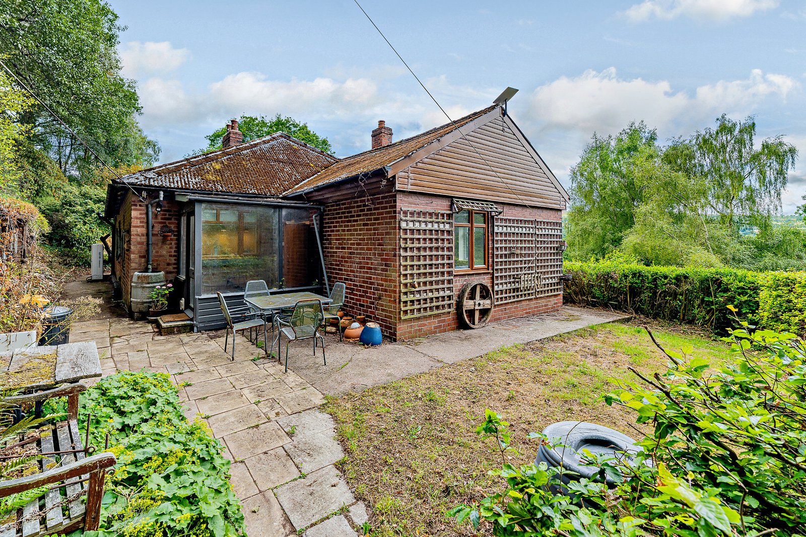 Secluded £520k woodland home in Shrewsbury with two bedrooms nearly one acre of gardens rare plants historic mine features and stunning views offers ultimate privacy.