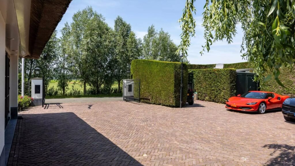 Thatched villa near Amsterdam features luxury interiors, a private boathouse, and a rare home office where you can park two supercars beside your desk.