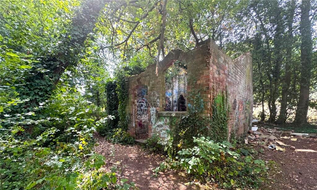 Derelict Bewdley schoolhouse with no roof listed for £40,000. The overgrown triangular plot, once staff housing, is up for auction and accessed only by bridle path.