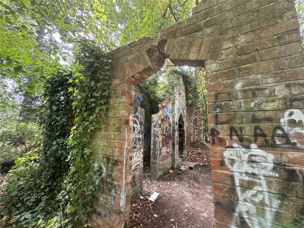 Derelict Bewdley schoolhouse with no roof listed for £40,000. The overgrown triangular plot, once staff housing, is up for auction and accessed only by bridle path.